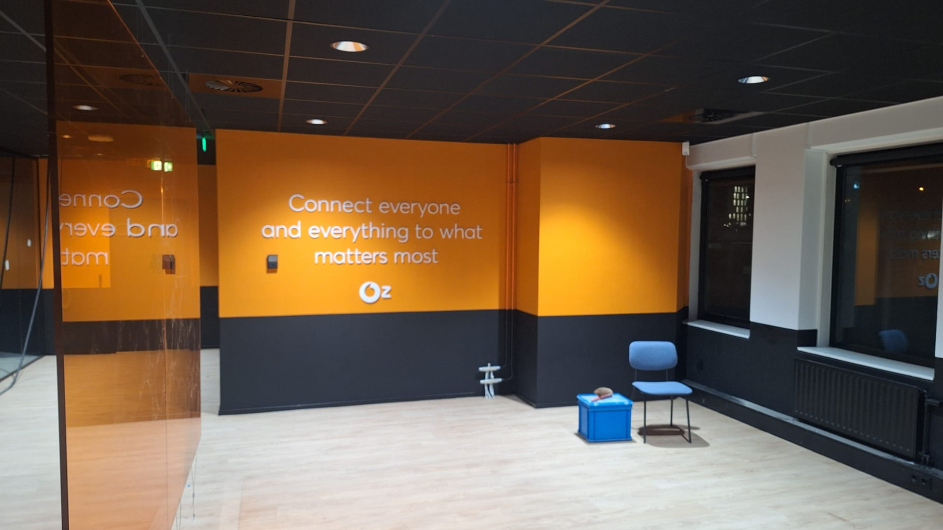 Oranje en antracietkleurige kantoorwand met bedrijfsslogan van VodafoneZiggo